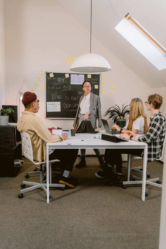 Team brainstorming session in a modern office with diverse professionals discussing ideas.